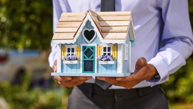 a person holding a house model